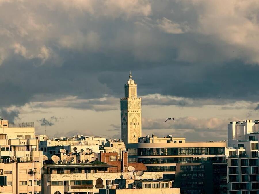 Un paisaje urbano con un minarete destacado, rodeado de edificios residenciales y comerciales.
