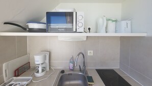 A kitchenette with a microwave, coffee maker, and a sink. - Studio Avec Piscine et Plages Accessibles à Pieds (Sainte-Luce)