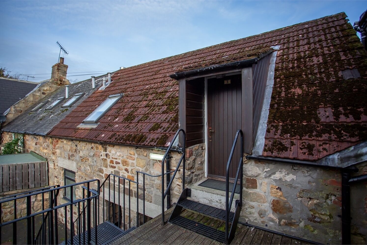 A stone building with a wooden door and a small window.