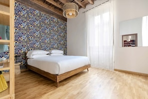 Ein Schlafzimmer mit einem hölzernen Bett, einer Wand mit Muster, einem Holzschrank und einer Pendelleuchte.