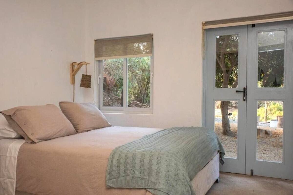 Un dormitorio con cama, ventana y puerta.