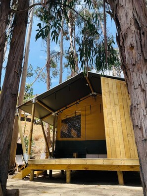 A small, wooden cabin with a slanted roof and a covered porch area. - Parque Laguna de Zapallar (Zapallar)