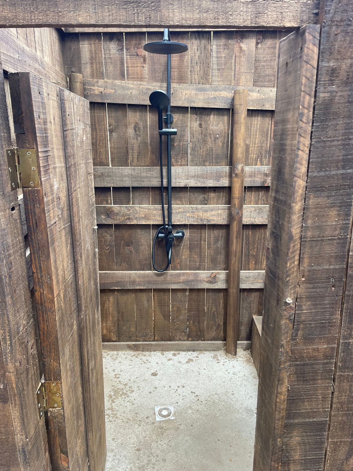 A wooden structure with a metal shower fixture.