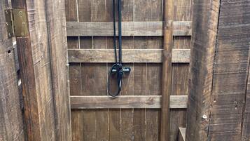 A wooden structure with a metal shower fixture.
