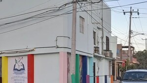 A building with a sign for an educational institution, a parked truck, and a street with power lines. - Central Location -"FRIDA" (Cabo San Lucas)