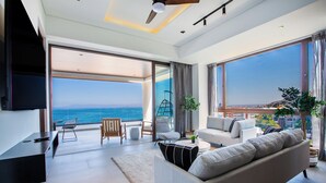 Un salon moderne avec un grand canapé, une table à manger et une vue sur la mer.