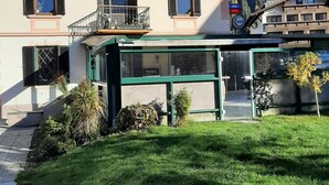 Un edificio con un letrero que dice 'Scotland Yard Pub', balcones y montañas al fondo.