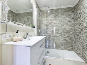 A modern bathroom with a glass shower enclosure, a white sink, and a mirror above it. - Charming flat for 6 people in Felanitx, Mallorca (Felanitx)