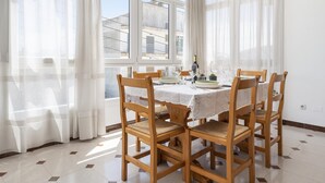A dining area with a table set for four, wooden chairs, and a view through large windows. - Charming flat for 6 people in Felanitx, Mallorca (Felanitx)