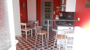 Una cocina compacta con piso a cuadros, una mesa de comedor con sillas y un refrigerador.