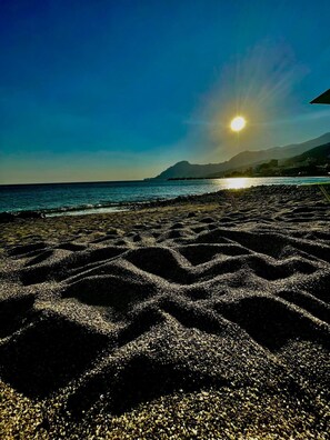 A beach with a clear sky and the sun setting or rising over the water. - Charming 2-bedroom hotel in serene Agios Vasileios with AC, WiFi (Agios Vasileios)