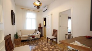 A living room with a sofa, a dining table, and a patterned floor. - Dar Khawla (Beirut)