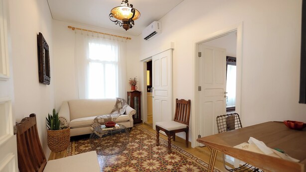 A living room with a sofa, a dining table, and a patterned floor. - Dar Khawla (Beirut)