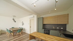 A modern kitchen with wooden cabinets, a built-in oven, and a countertop. - Villetta Bucaneve - Locz (Padenghe sul Garda)