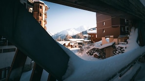 A snowy mountain village with buildings and a mountain in the background. - 150m from resort center, 7th floor, balcony, ski locker, 31m², La Tania (Courchevel)
