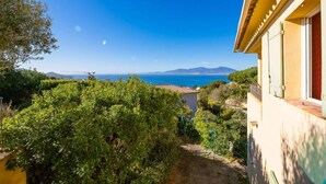A coastal view with a building, greenery, and a clear sky. - Maison en Bord de mer - Casa L'albitronu (Pietrosella)