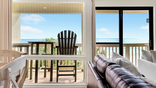 A balcony with a view of the ocean, a wooden chair, a table, and a leather sofa. - ☀️Gulf Front Condo with Great Views-Latitude 29 #36☀️ (Panama City Beach)