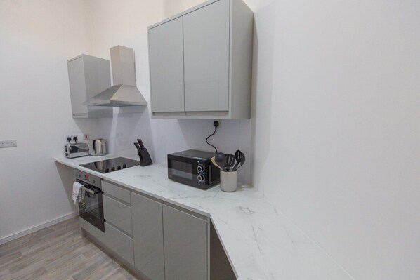 A modern kitchen with a built-in oven, microwave, and gas stove.