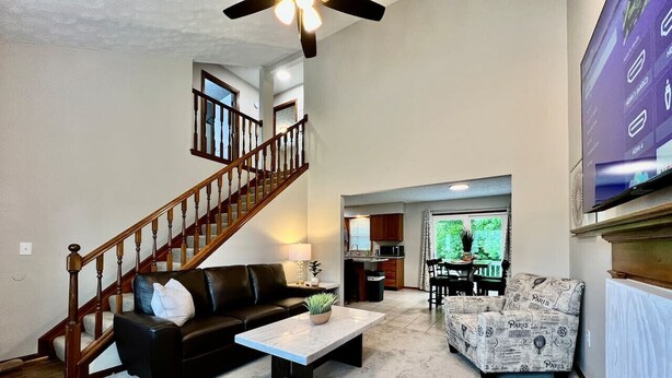 A spacious living room with a staircase, a dining area, and a kitchen. - Newly Remodeled home in Liberty (Liberty Township)