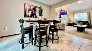 A living room with a dining area, a TV, and a window with curtains. - Newly Remodeled home in Liberty (Liberty Township)