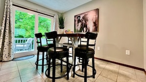 A dining area with a table and four chairs, a potted plant, and a painting on the wall. - Newly Remodeled home in Liberty (Liberty Township)