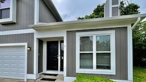 A two-story house with a garage, a front door, and a window with blinds. - Newly Remodeled home in Liberty (Liberty Township)