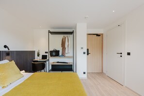 A modern bedroom with a bed, a desk, a chair, and a wardrobe. - 106 - Appart'Hôtel Neostelia-Annecy (Annecy)