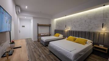 A modern hotel room with two beds, a wooden table, and a TV.