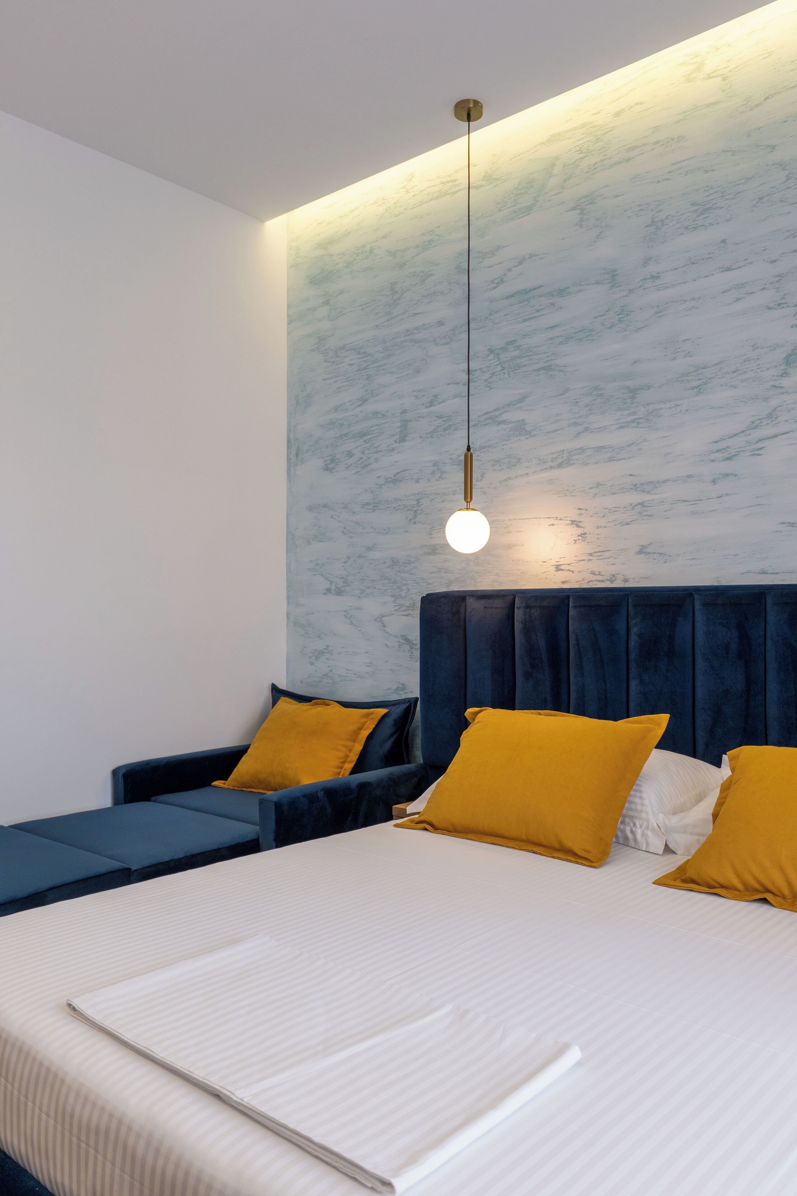 A modern bedroom with a large bed, two bedside tables, and a unique wall design.