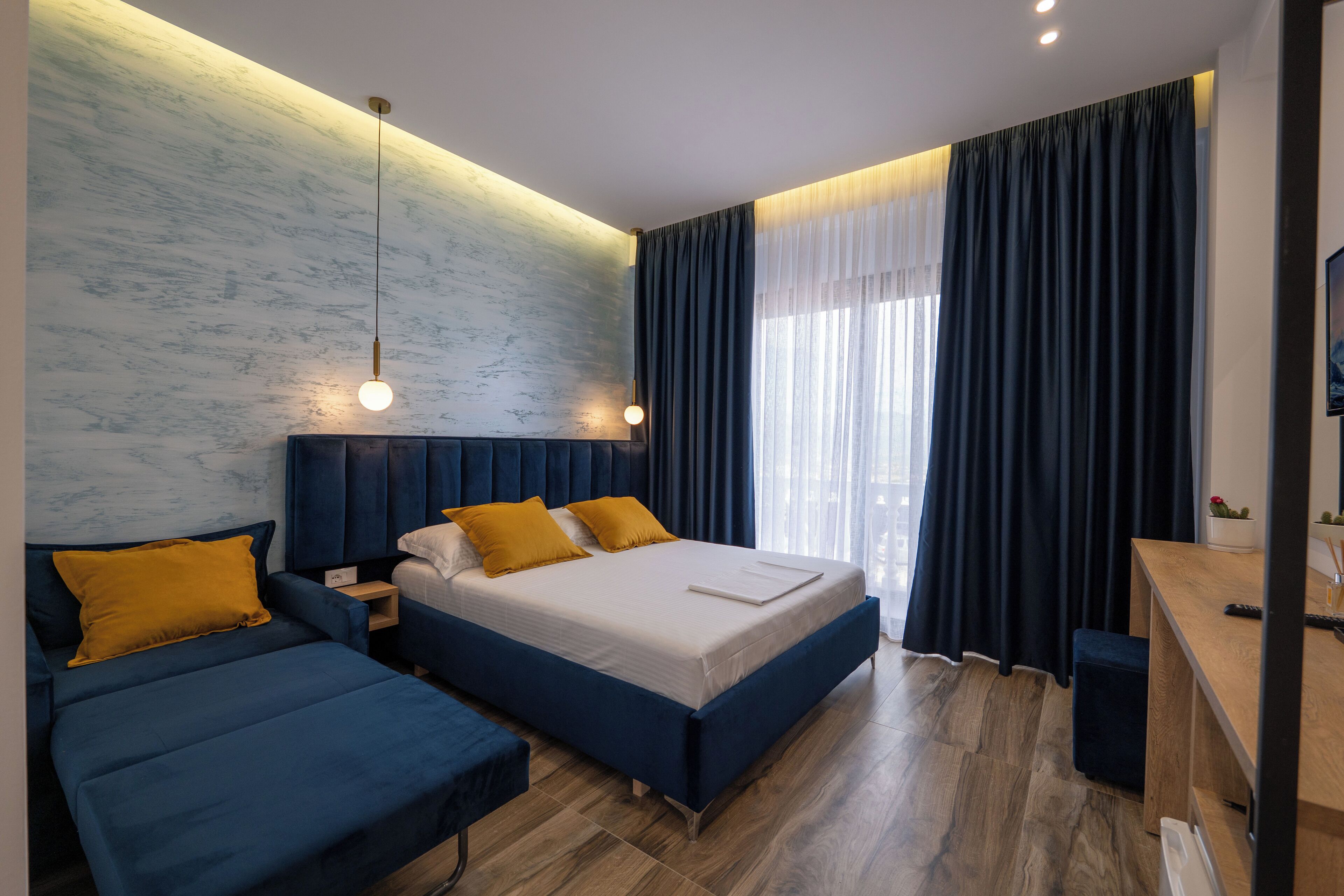 Une chambre à coucher moderne avec un grand lit, deux tables de chevet et un bureau.