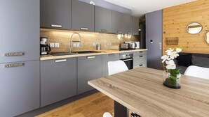 Una cocina moderna con armarios grises, una encimera de madera y una mesa de comedor con sillas.