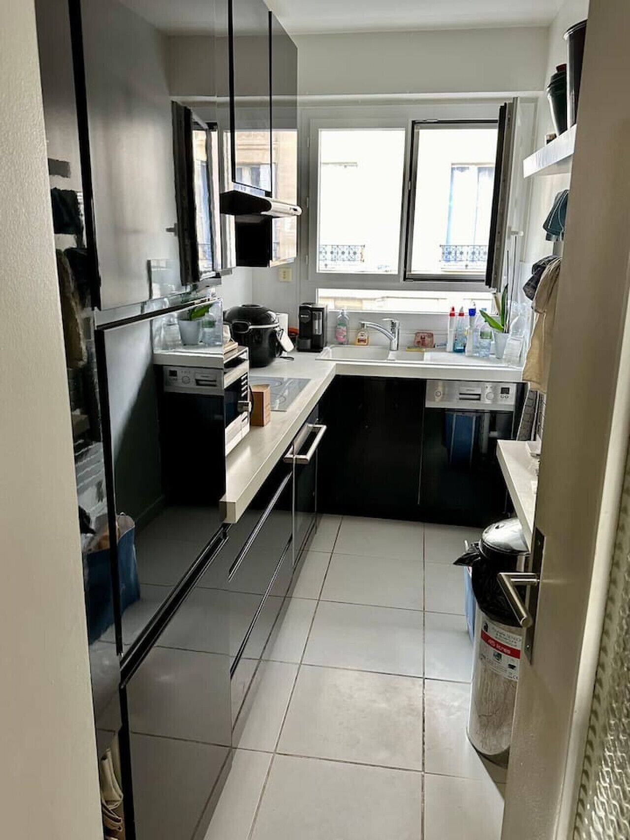 Una cucina compatta con elettrodomestici moderni, una finestra e vista all'esterno.