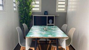 Un coin repas avec une table, des chaises et une plante en pot.