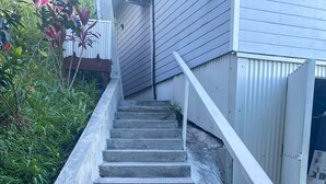 Una escalera de hormigón que sube hacia un edificio con fachada blanca.