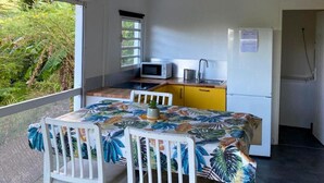 A compact kitchen with a dining area, a microwave, a sink, and a refrigerator.