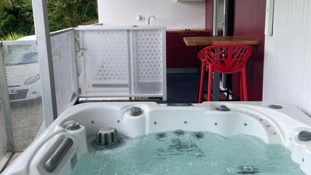 Ein Whirlpool mit Tisch und Stühlen, einer Mikrowelle und einer kleinen Küchenzeile.