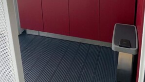 Eine kleine Küche mit einer Mikrowelle, zwei Spülen und einem Mülleimer.
