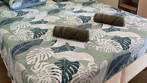 Ein Schlafzimmer mit Bett, Fenster und Kleiderschrank.