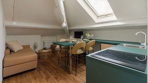 Cocina compacta con comedor, sofá y tragaluz.