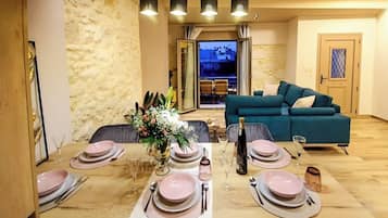 A dining area with a table set for four, a sofa, and a view of the outside.