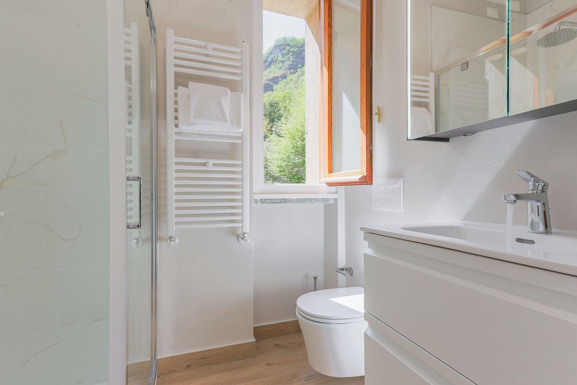 Een badkamer met douche, toilet en wastafel.