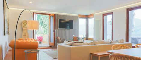 Una sala de estar moderna con sofá, mesa de comedor y televisor.