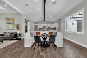 A modern kitchen with white cabinets, a central island, and pendant lighting. - Modern Farmhouse Bliss: Spacious Retreat with Private Pool & Fun Backyard Oasis (Phoenix)