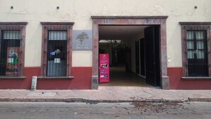 Un edificio con un cartello che riporta la scritta "THE LIT 13" e una targa rosa.