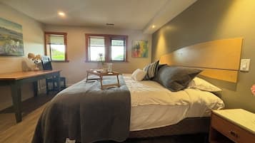 A bedroom with a bed, bedside table, and a desk.