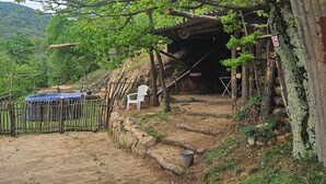 A rustic wooden structure with a dirt path leading to a covered entrance. - Maison de Campagne au Coeur du Parc Naturel Regional des Monts D'ardeche (Issamoulenc)