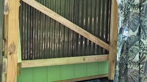 Eine grüne Holzkonstruktion mit einem Metallgitterboden und einer Holzplattform.