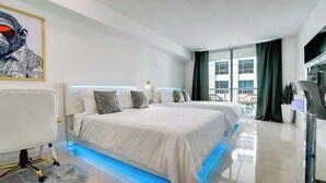 Ein modernes Hotelzimmer mit zwei Betten, einem großen Fenster und einem Balkon.