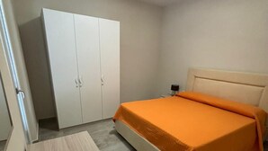 A bedroom with a bed, a wardrobe, and a desk. - 3 Bedroom Apartment in Santa Maria (Santa Maria)