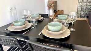 A dining table set with plates, bowls, and wine glasses. - Appartement Laranceto vue mer Avec Piscine (Biguglia)